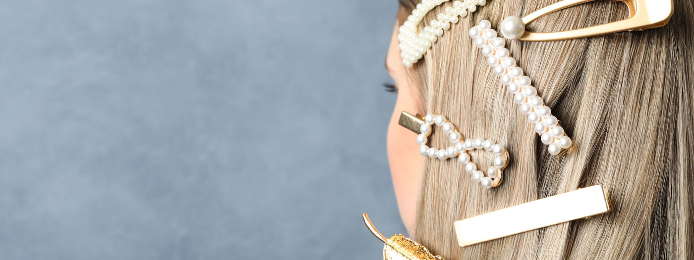 Stylish pearl and gold hair clips on blonde hair
