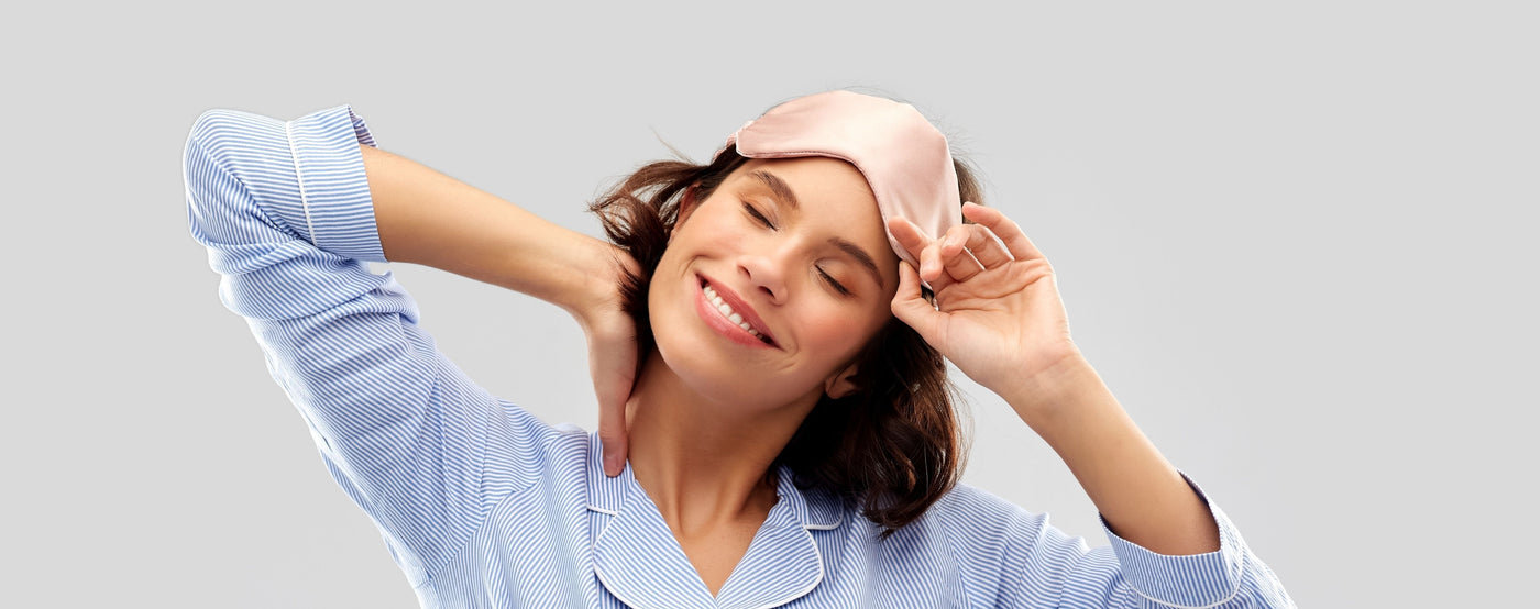 Brunette Woman in blue pyjamas and a silk sleep mask