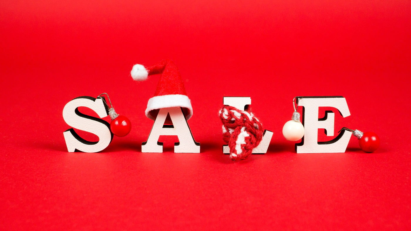 Girl holding red shopping bags saying SALE on a pink background