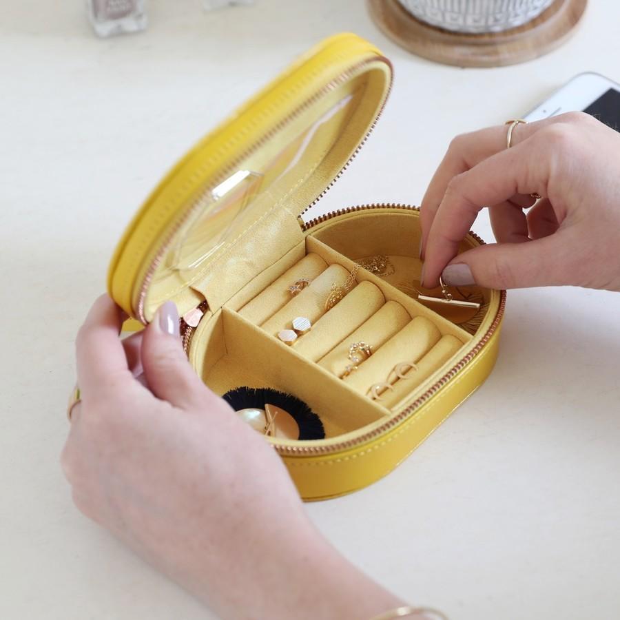 Women's hands opening a yellow jewellery box