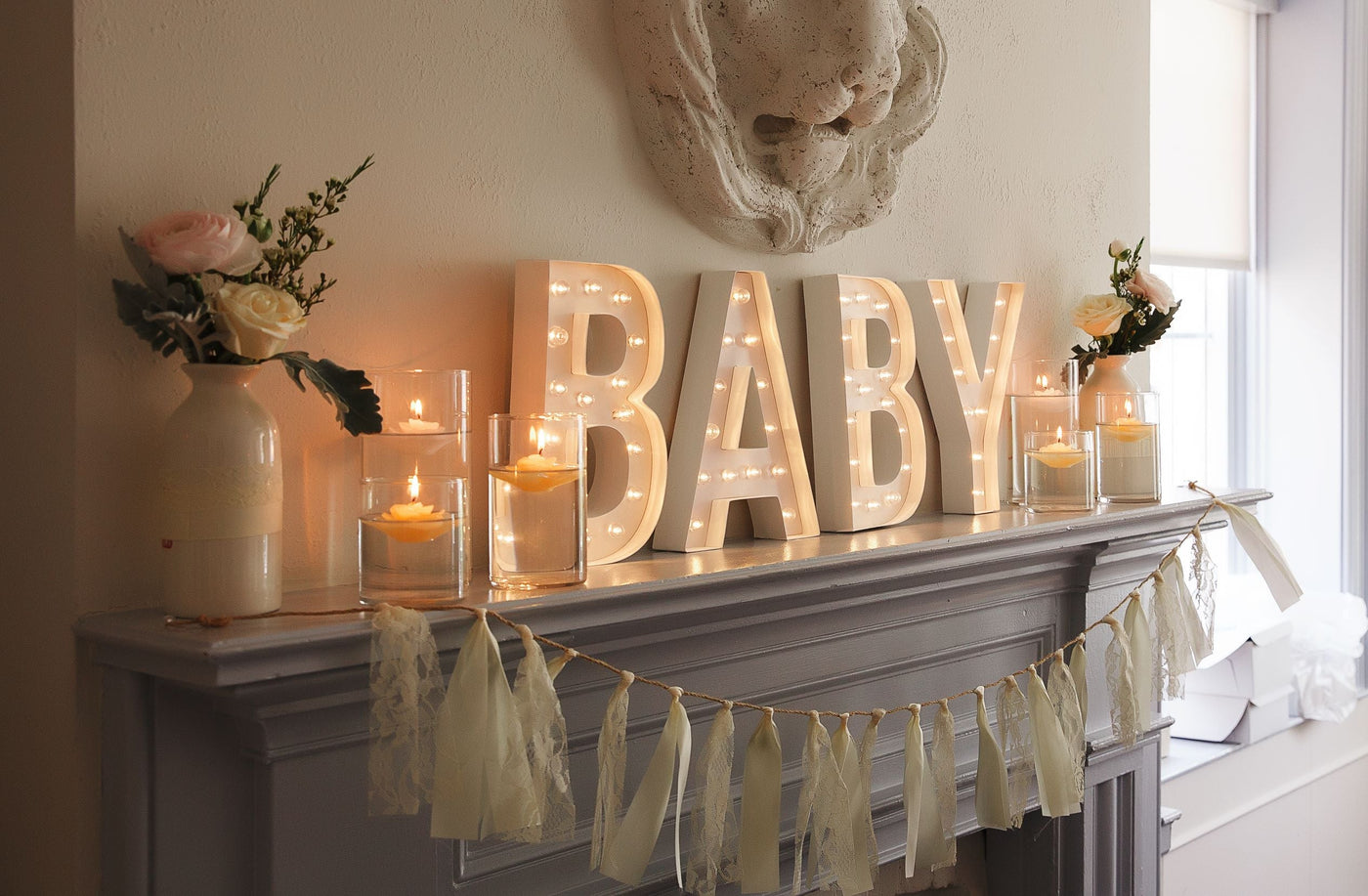Light up box words spelling BABY on fireplace mantel